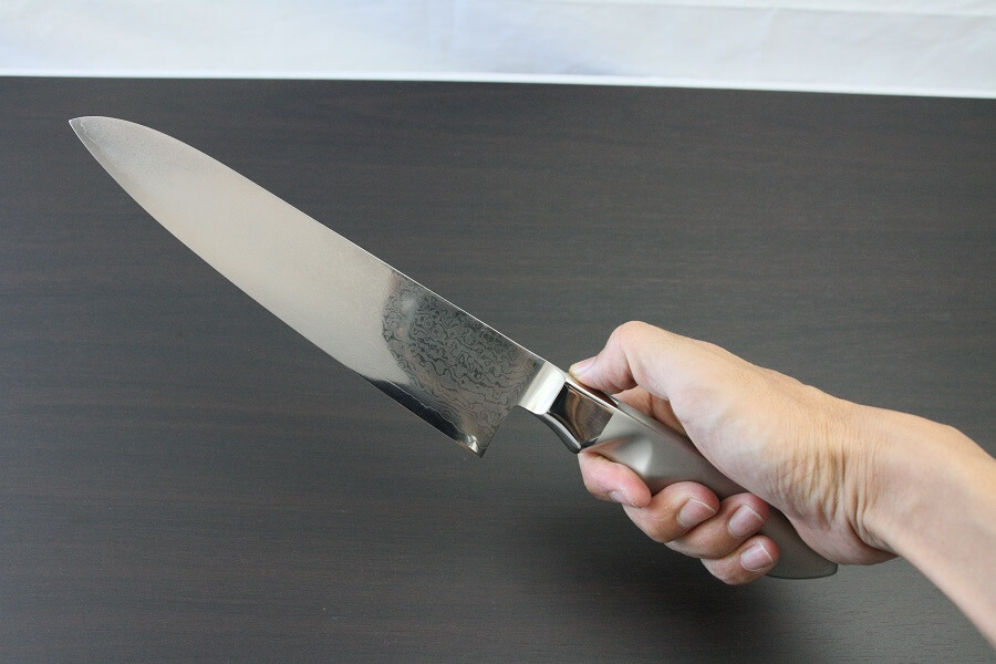 DamMona_Gyuto210_08 Japanese Chef Knife, Damascus Gyuto size M, grabbed by man's hand