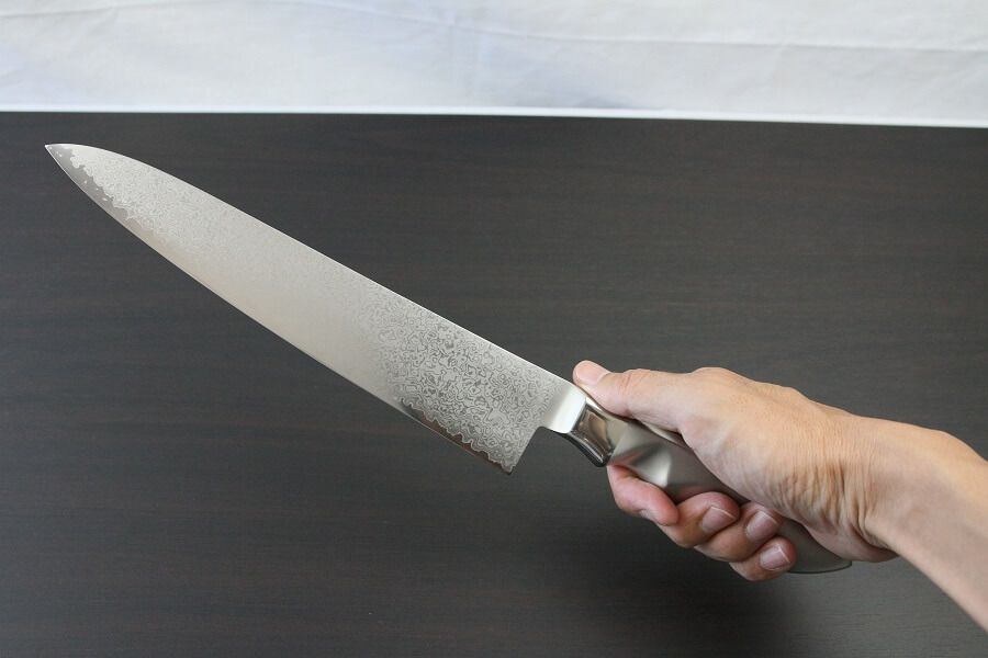 DamMona_Gyuto240_08 Japanese Chef Knife, Damascus Gyuto size L, grabbed by man's hand