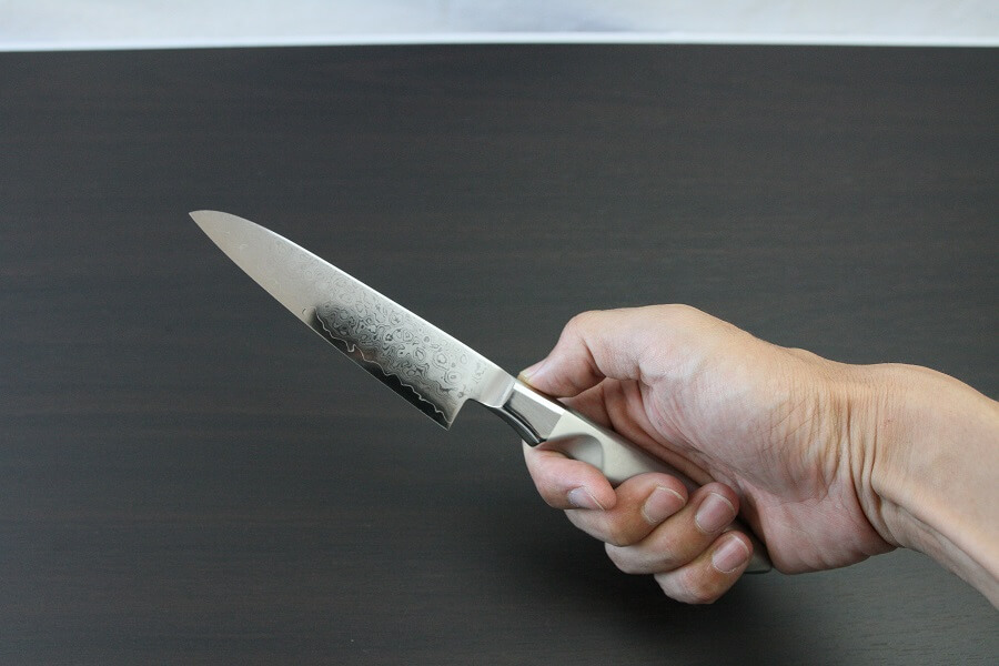 DamMona_Petit_08 Japanese Chef Knife, Petit utility knife size 120mm, grabbed by a man's hand