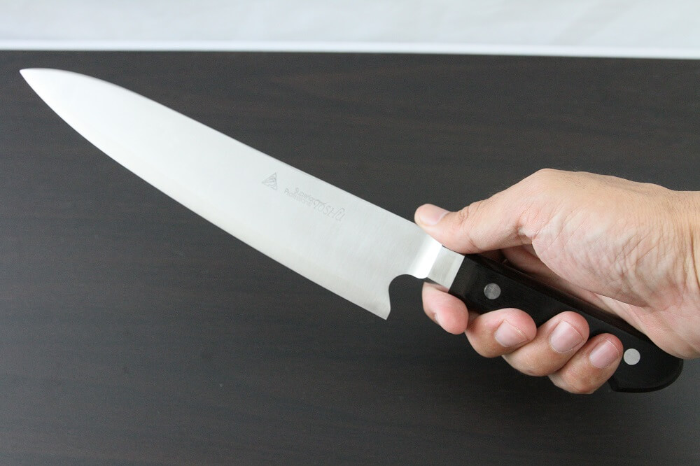 HSS_Gyuto210_08 Japanese Highest Quality Chef Knife, Tohu Powder high-speed steel Series, Gyuto chef knife 210mm, grabbed by a man's hand