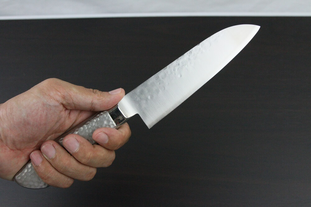 hamfin_santoku150L_08 Japanese Chef Knife, Hammer Finish Series, Santoku multi-purpose knife 150mm left-handed, grabbed by a man's hand