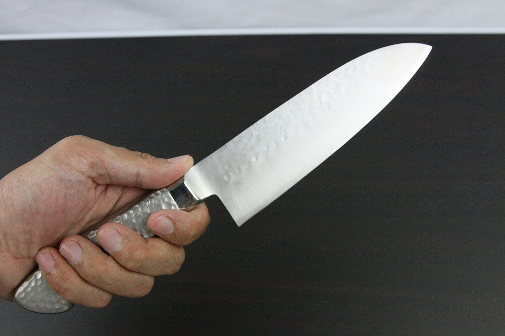 hamfin_santoku165L_08 Japanese Chef Knife, Hammer Finish Series, Santoku multi-purpose knife 165mm left-handed, grabbed by a man's hand