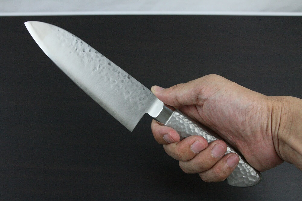 hamfin_santoku165_08 Japanese Chef Knife, Hammer Finish Series, Santoku multi-purpose 165mm, grabbed by a man's hand