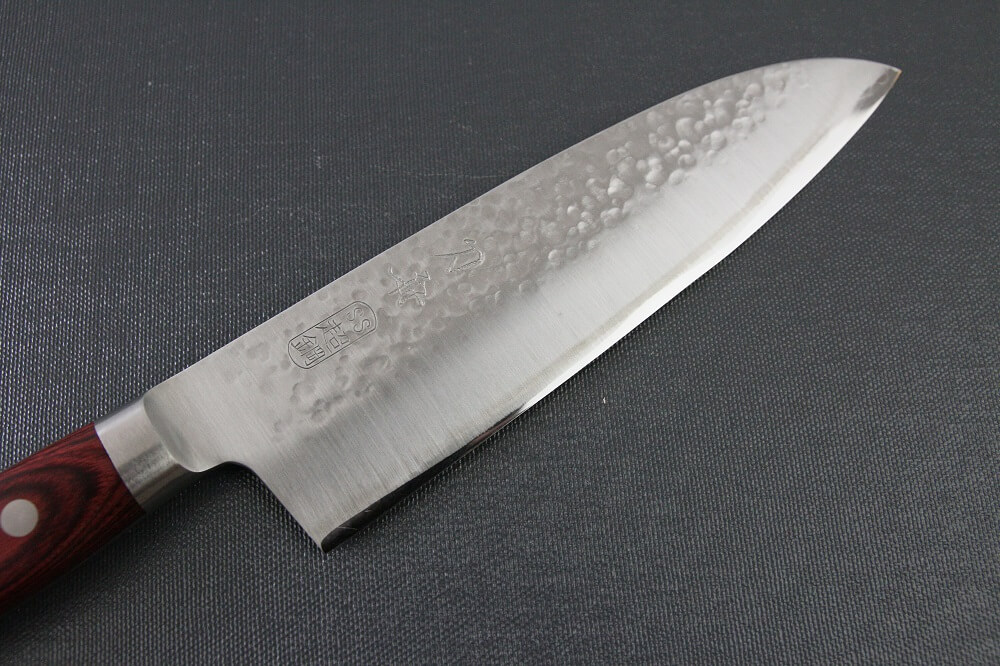 spsantoku_hamfin_red_IMG_6216 Toshu Santoku multi-purpose Japanese chef's knife, hammered finish blade and red handle, details of blade front side