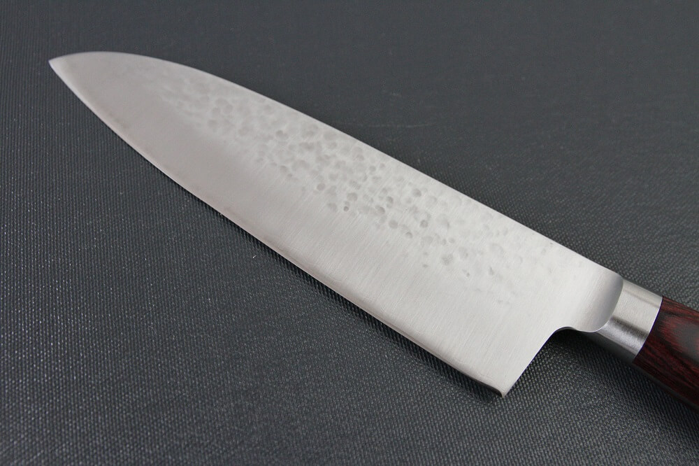 spsantoku_hamfin_red_IMG_6218 Toshu Santoku multi-purpose Japanese chef's knife, hammered finish blade and red handle, details of blade backside