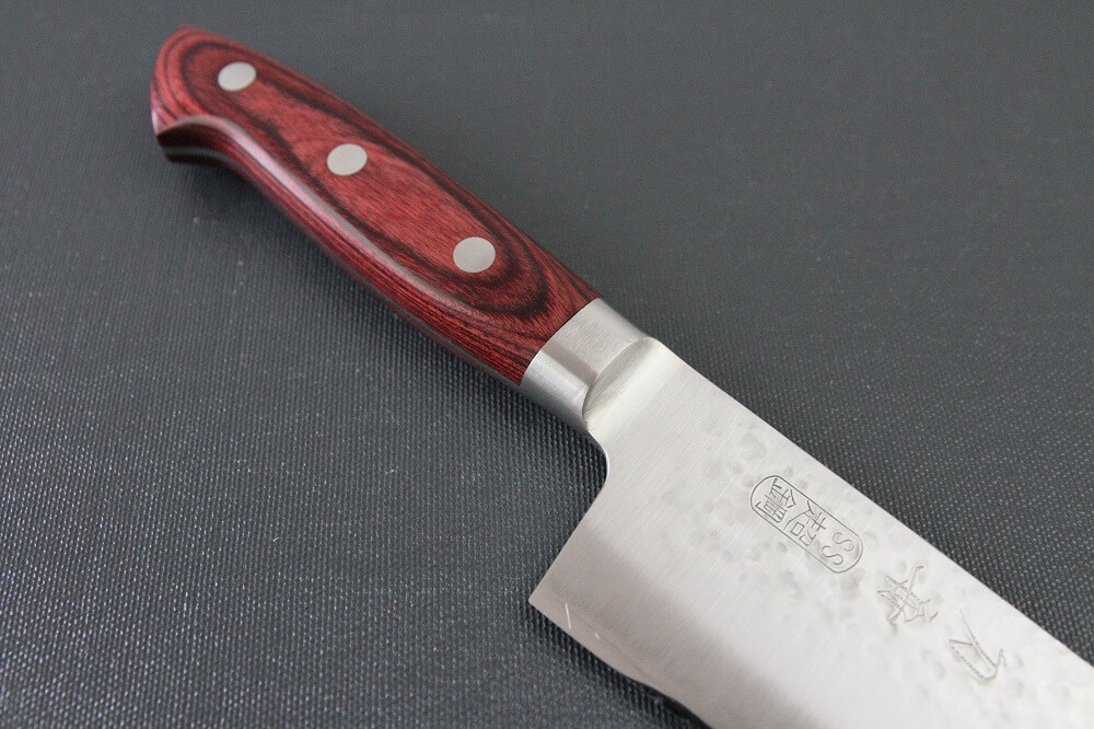spsantoku_hamfin_red_IMG_6222 Toshu Santoku multi-purpose Japanese chef's knife, hammered finish blade and red handle, diagonal front view